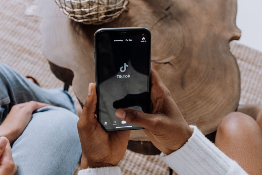 Person hält ein Handy. mit geöffneter TikTok App